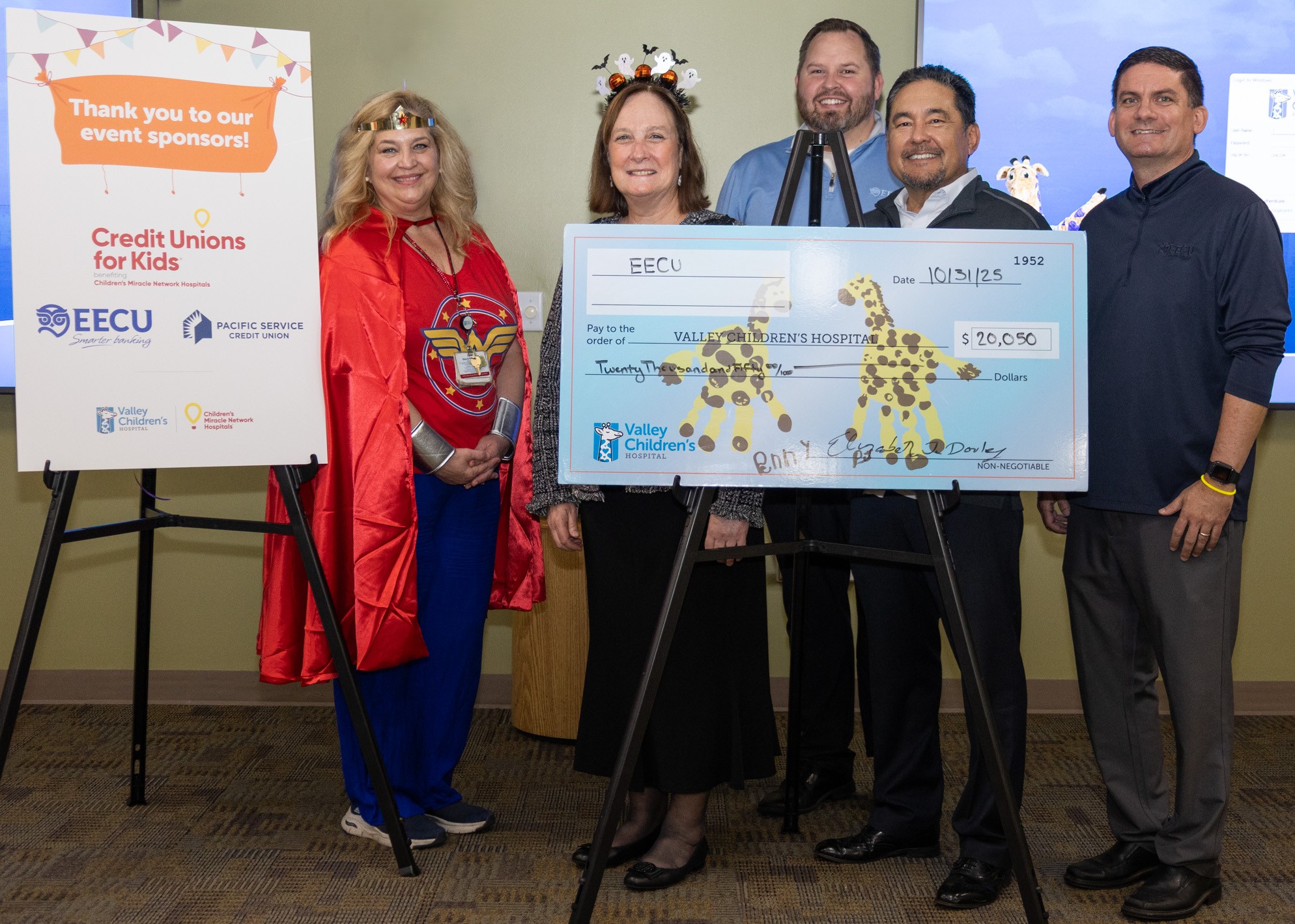 Group of four EECU representatives providing a enlarged check for $20,500 to a representative for Valley Children's Hospital